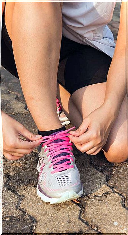 Woman tying lacing of sports shoes